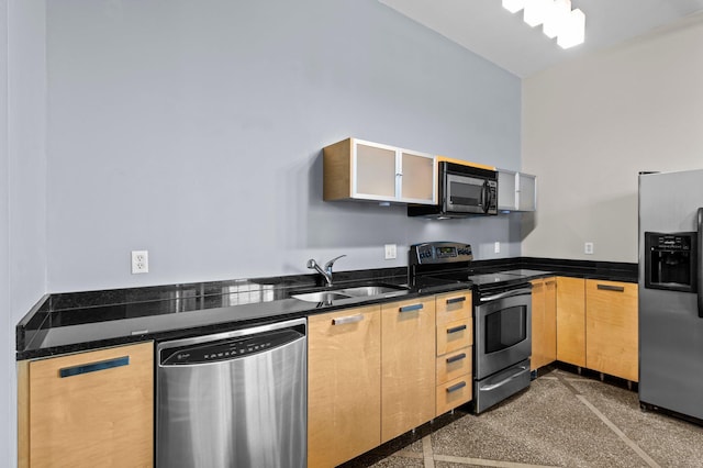 kitchen featuring appliances with stainless steel finishes, sink, light brown cabinets, and dark stone counters