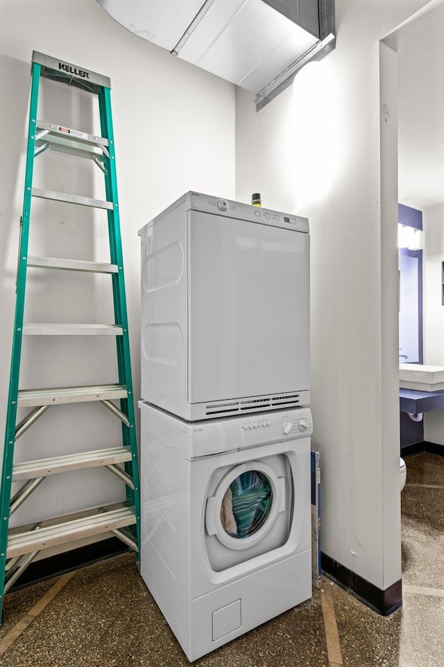 clothes washing area featuring stacked washing maching and dryer