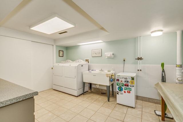 1755 Glenview Ave, Arden Hills, MN 55112 - laundry room featuring light tile patterned flooring, separate washer and dryer, a sink, tile walls, and a wainscoted wall