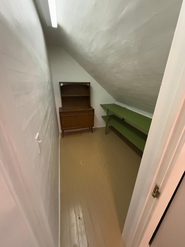 additional living space with wood-type flooring and lofted ceiling