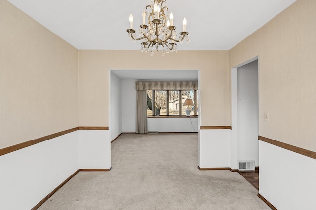 unfurnished dining area featuring an inviting chandelier and light colored carpet