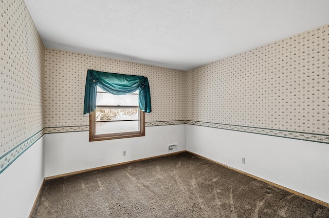 carpeted empty room featuring a textured ceiling