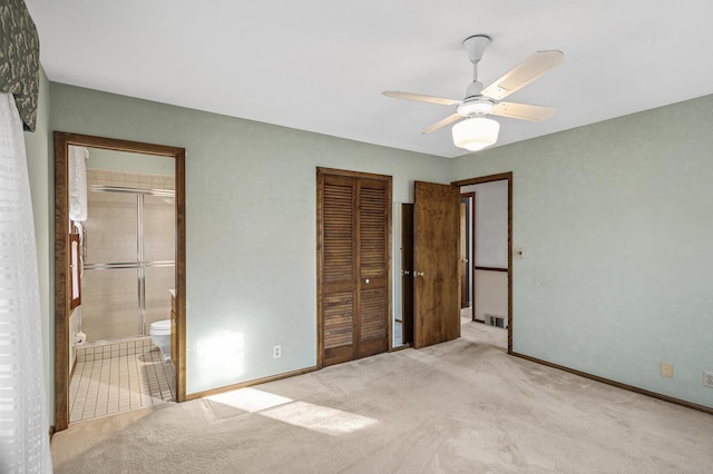 unfurnished bedroom with light colored carpet, ceiling fan, and ensuite bathroom