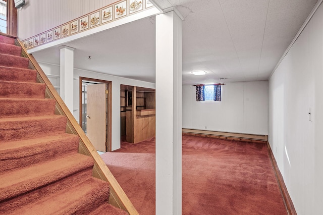 basement featuring baseboard heating and carpet