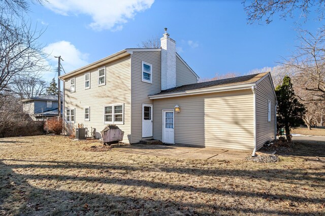 back of property with cooling unit and a yard