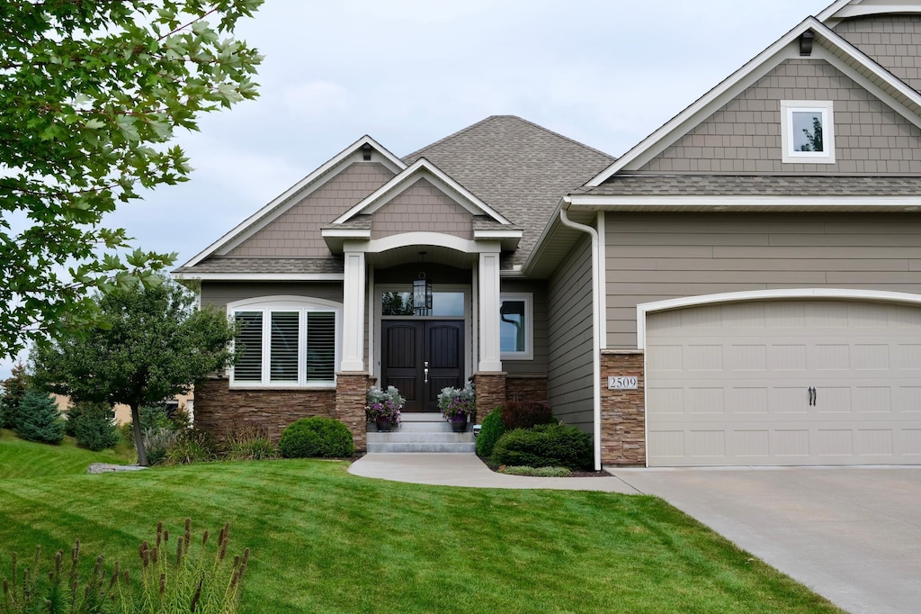 craftsman house with a garage and a front lawn