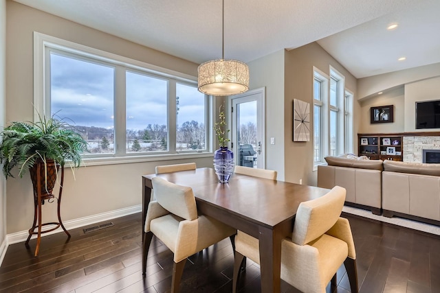 dining room featuring a fireplace and dark hardwood / wood-style flooring