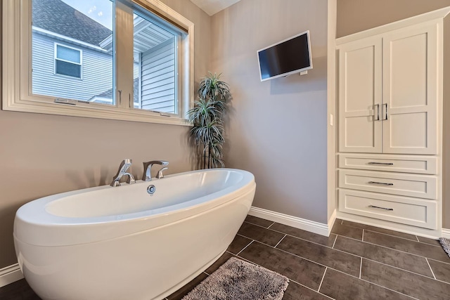 bathroom featuring tile patterned flooring and a tub to relax in