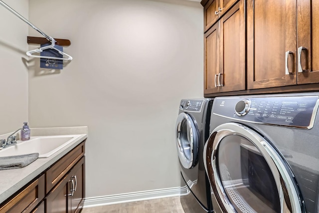 laundry area featuring cabinets, sink, and independent washer and dryer