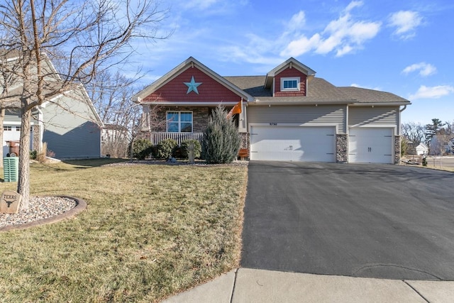 view of front of house with a front lawn, covered porch, and a garage