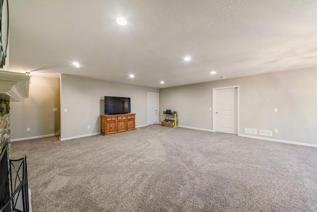 unfurnished living room with a fireplace, carpet, and a textured ceiling