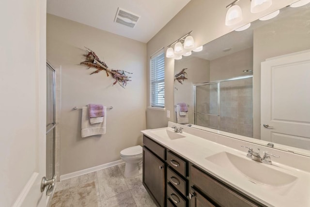 bathroom with vanity, toilet, and a shower with shower door