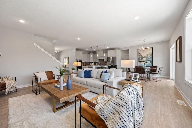 living room featuring a notable chandelier and light hardwood / wood-style flooring