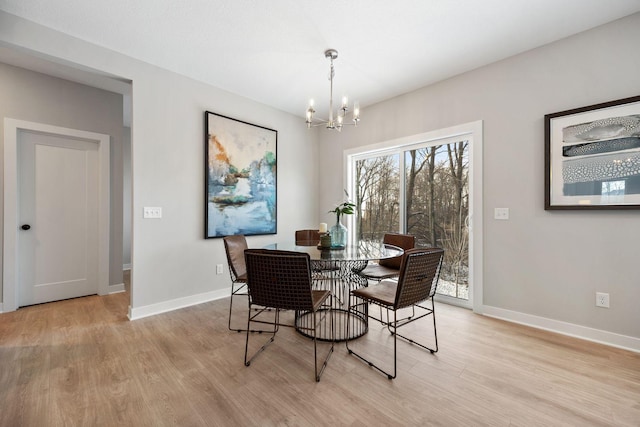 dining space with a notable chandelier and light hardwood / wood-style floors