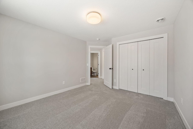 unfurnished bedroom with a closet and carpet floors