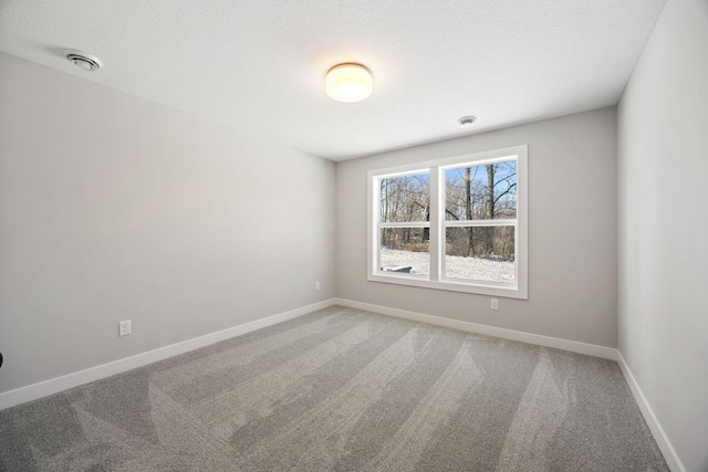 carpeted empty room featuring a textured ceiling