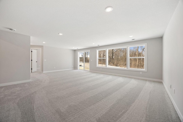 carpeted spare room with a textured ceiling