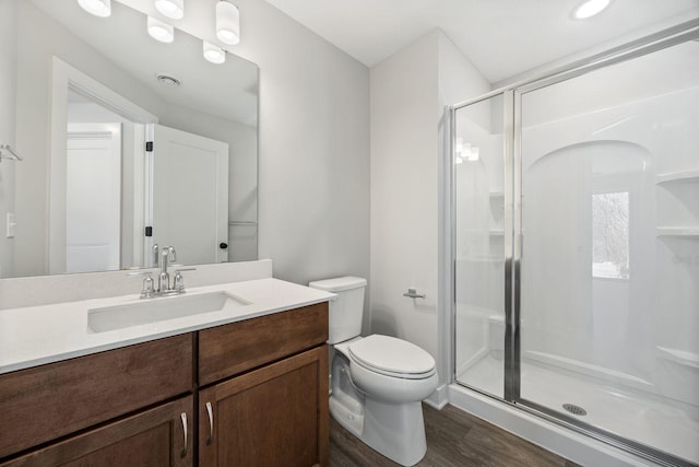 bathroom with toilet, an enclosed shower, wood-type flooring, and vanity