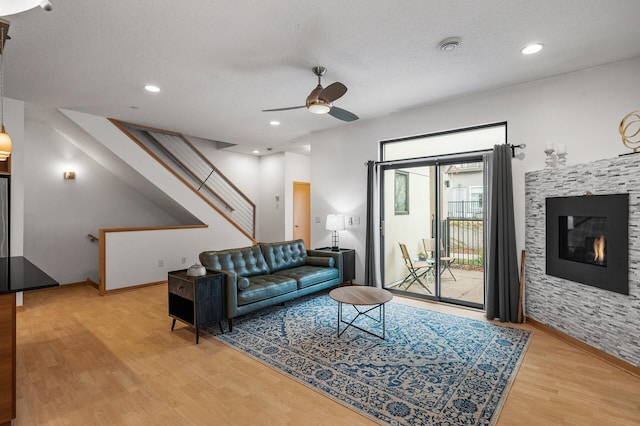 living room featuring hardwood / wood-style floors, a textured ceiling, and ceiling fan