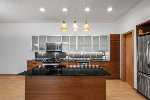 kitchen featuring tasteful backsplash, a center island, pendant lighting, and appliances with stainless steel finishes