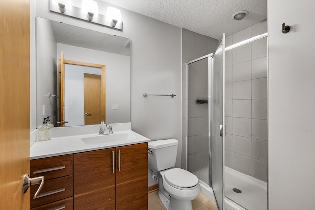 bathroom featuring tile patterned flooring, vanity, toilet, and an enclosed shower