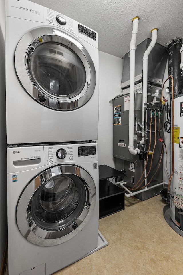 laundry area featuring a textured ceiling, gas water heater, and stacked washer and clothes dryer