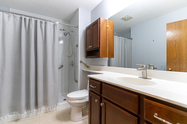 bathroom with a textured ceiling, vanity, toilet, and curtained shower