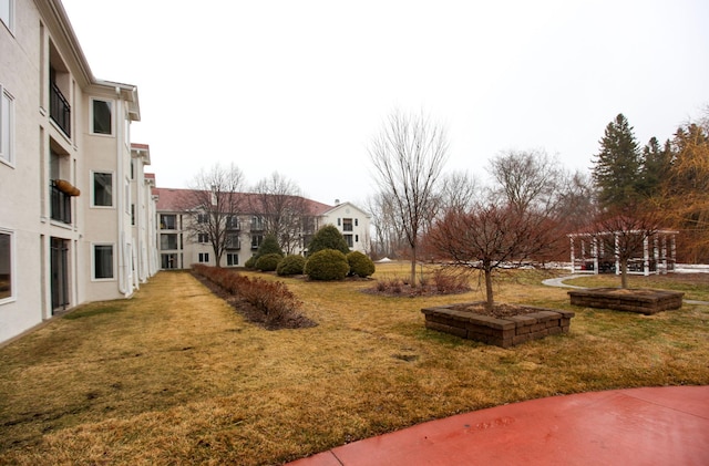 view of home's community featuring a lawn and a pergola