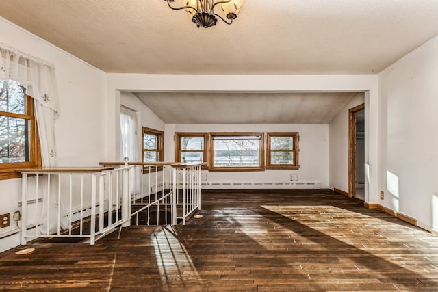 spare room with lofted ceiling with beams, dark wood-type flooring, a wealth of natural light, and an inviting chandelier