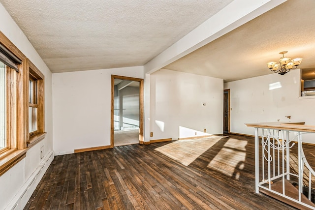 spare room featuring lofted ceiling, a baseboard heating unit, dark hardwood / wood-style floors, a textured ceiling, and a chandelier