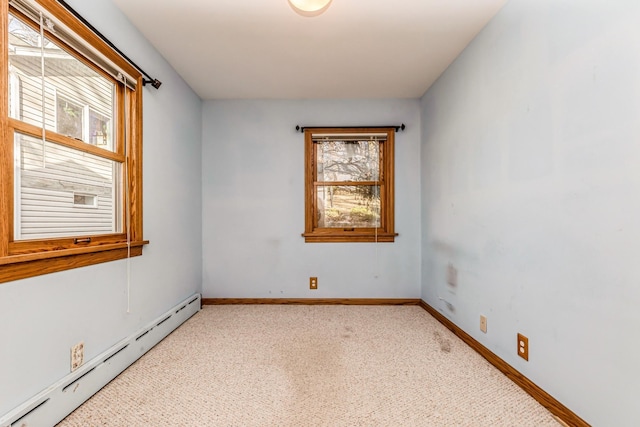 empty room featuring light carpet and a baseboard heating unit