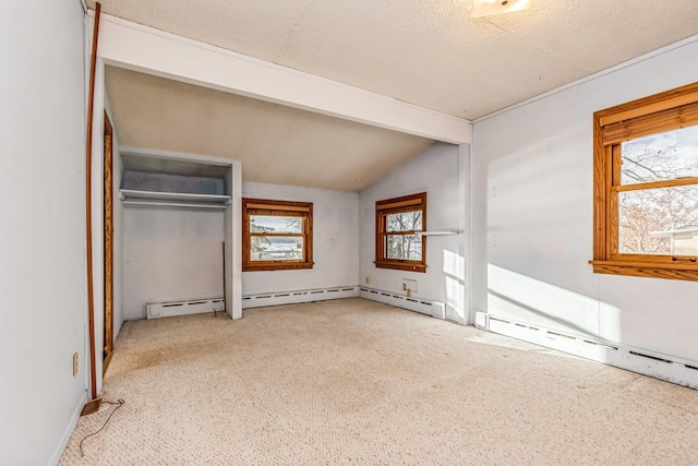 unfurnished bedroom with light carpet, vaulted ceiling with beams, a closet, and a baseboard heating unit