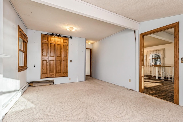 carpeted empty room with a textured ceiling and baseboard heating