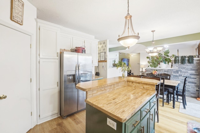 kitchen featuring pendant lighting, wooden counters, a kitchen island, white cabinetry, and stainless steel fridge with ice dispenser