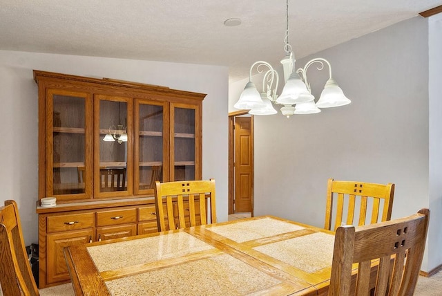 carpeted dining space with a chandelier and vaulted ceiling