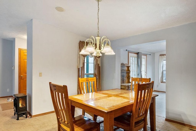 carpeted dining room with a wood stove and a notable chandelier