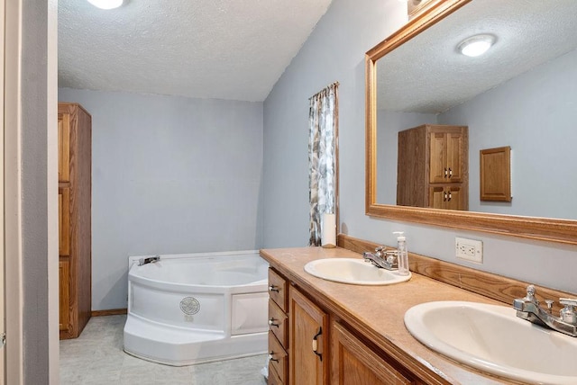 bathroom featuring vanity, a textured ceiling, and a bathtub