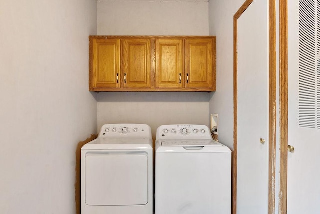 laundry room with washer and dryer and cabinets