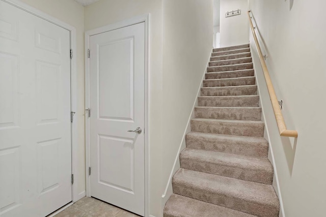 staircase featuring tile patterned flooring