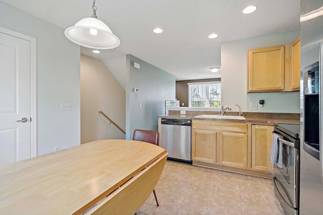 kitchen featuring light brown cabinets, stainless steel appliances, decorative light fixtures, and sink