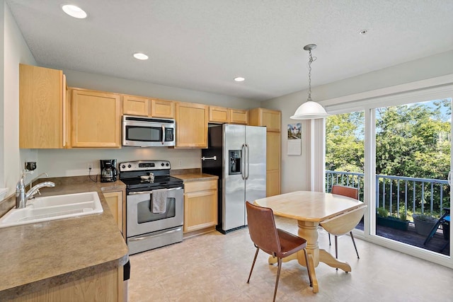 kitchen featuring appliances with stainless steel finishes, a textured ceiling, sink, light brown cabinets, and decorative light fixtures