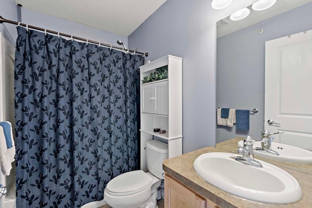 bathroom featuring vanity, a textured ceiling, toilet, and walk in shower