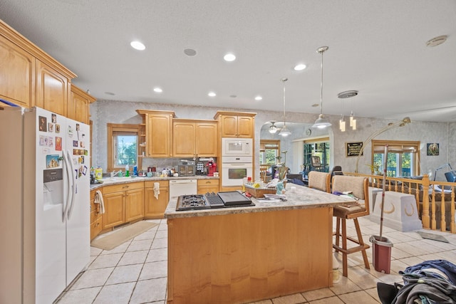 3078 70th St SW, Waverly, MN 55390 - kitchen with white appliances, a kitchen island, recessed lighting, light tile patterned floors, and light countertops