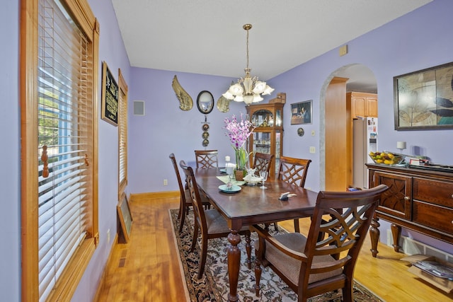 3078 70th St SW, Waverly, MN 55390 - dining room featuring arched walkways, light wood-style flooring, and a chandelier