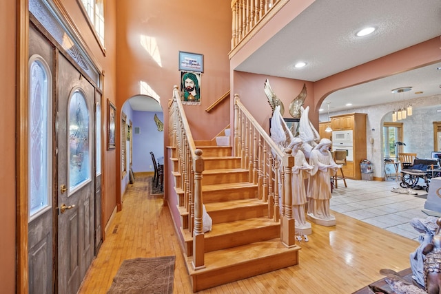3078 70th St SW, Waverly, MN 55390 - foyer featuring arched walkways, stairs, light wood finished floors, baseboards, and a towering ceiling