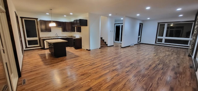 kitchen with sink, decorative light fixtures, a center island, and hardwood / wood-style flooring