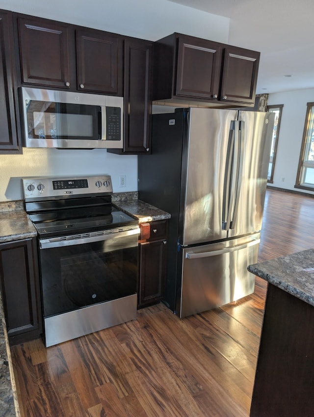 kitchen with appliances with stainless steel finishes, dark hardwood / wood-style floors, and dark brown cabinets