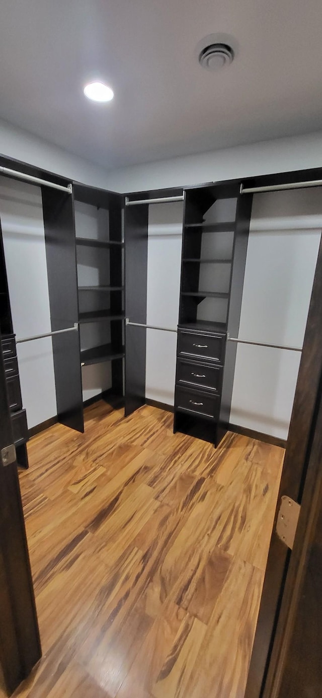 walk in closet with light wood-type flooring