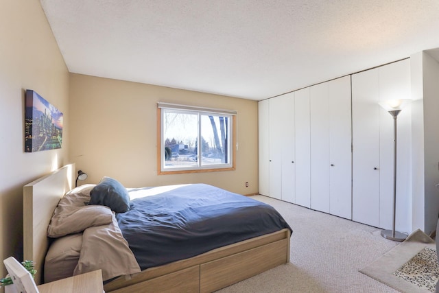 bedroom featuring light colored carpet and a textured ceiling