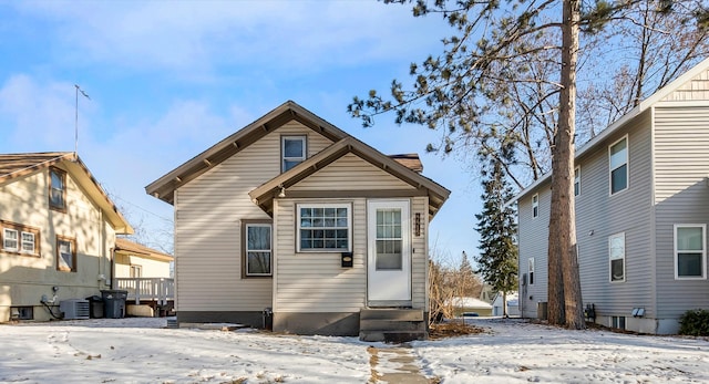 snow covered property with central air condition unit